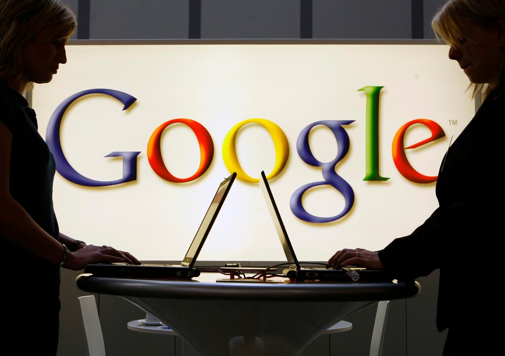 FILE - In this April 17, 2007 file photo, exhibitors work on laptop computers in front of an illuminated Google logo at the industrial fair Hannover Messe in Hanover, Germany.(AP Photo/Jens Meyer, File)