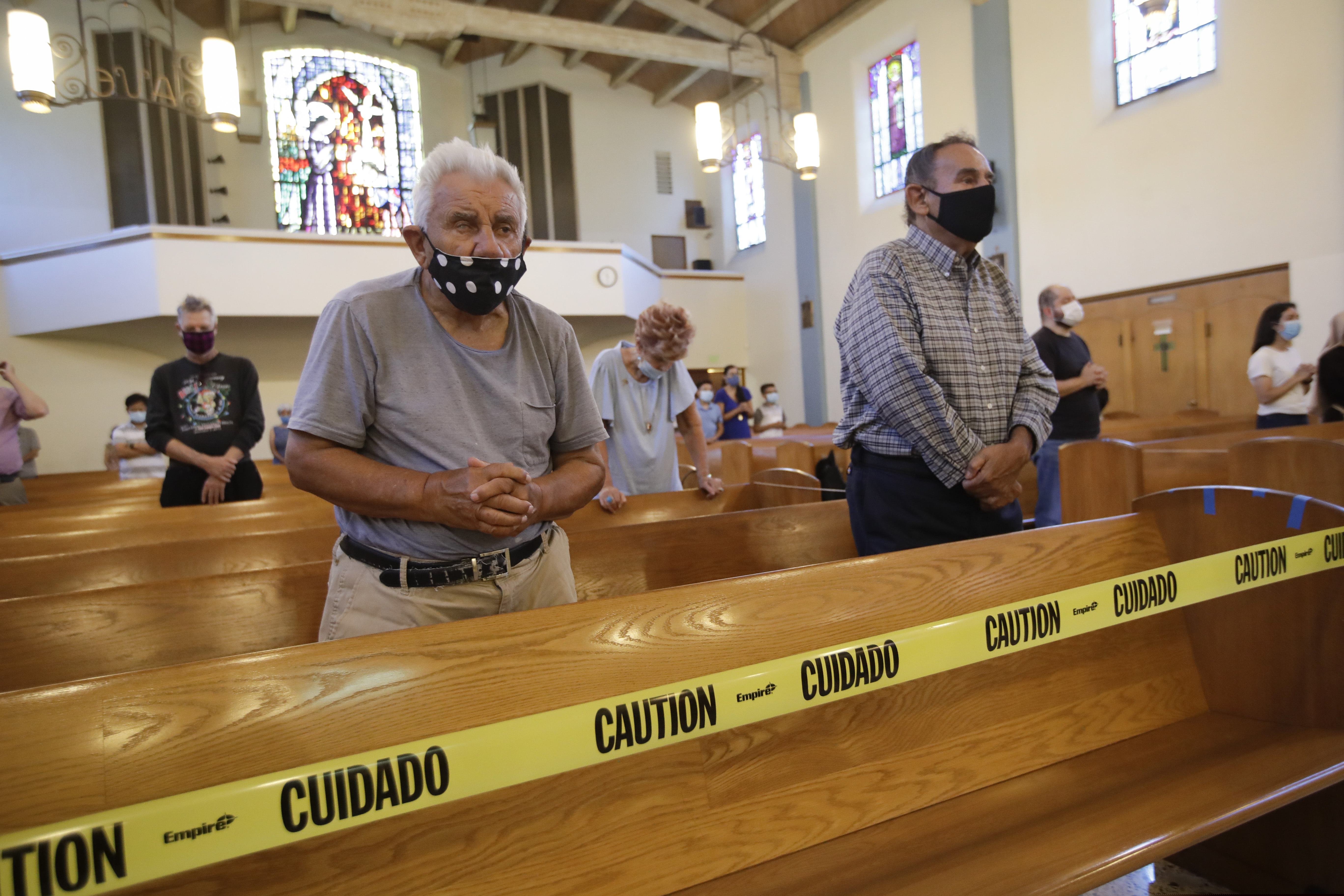 (Marcio Jose Sanchez | The Associated Press) Faithful pray while yellow tape enforces social distance amid the coronavirus pandemic at the San Gabriel Mission Sunday, July 12, 2020, in San Gabriel, Calif. A fire on Saturday destroyed the rooftop and most of the interior of the nearly 250-year-old California church that was undergoing renovation.
