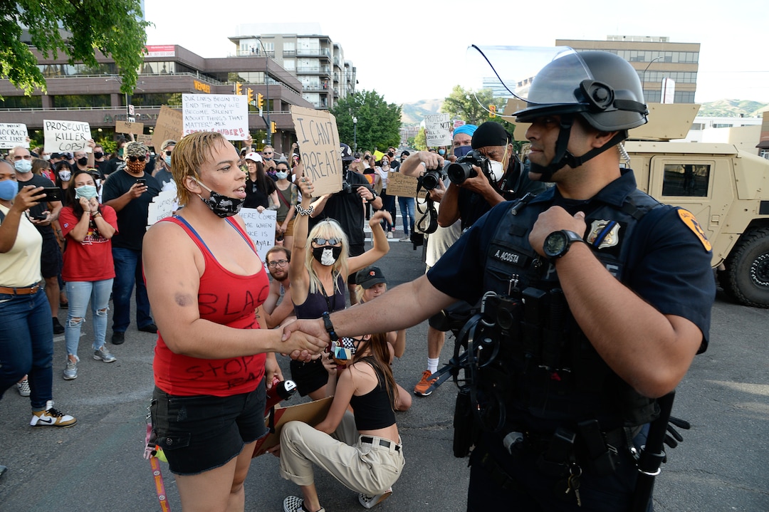 (Francisco Kjolseth  |  The Salt Lake Tribune) Victoria Crosby with Black Lives Matter receives a hand shake from officer M. Acosta as demonstrators protest against police brutality on Tuesday, June 2, 2020, in downtown Salt Lake City, as an 8 p.m. weeklong curfew remains in order.