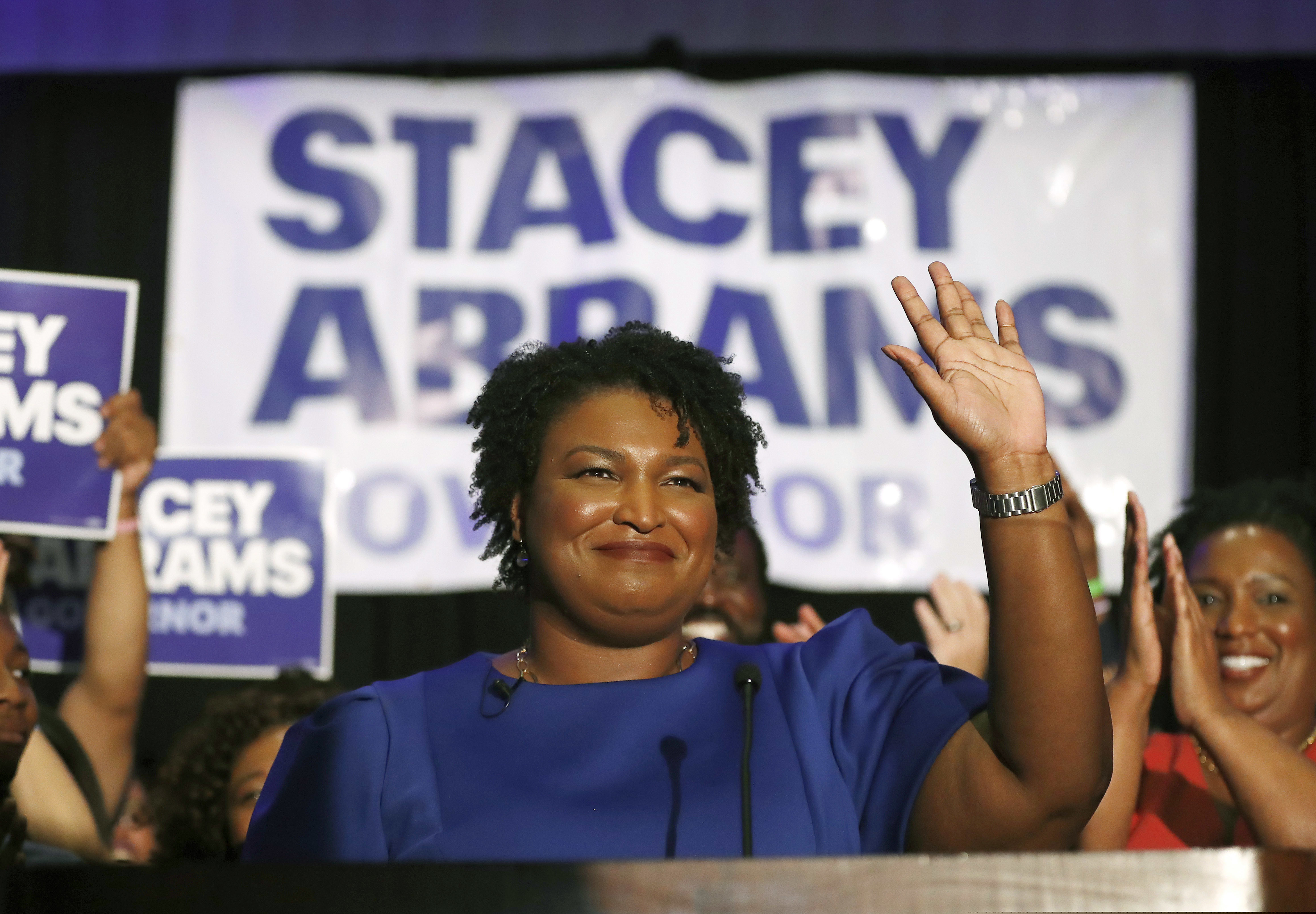 FILE- In this May 22, 2018, file photo Democratic candidate for Georgia Gov. Stacey Abrams waves at a campaign event in Atlanta. The final stretch of the hotly contested Georgia governor's race is being consumed by a bitter political battle over access to the polls. Secretary of State Brian Kemp, the Republican gubernatorial candidate, says that Abrams is fighting for immigrants without legal status to cast ballots in the Nov. 6 election. Abrams' campaign says that's untrue and Kemp is trying to deflect from his own record of making it harder for legal citizens to vote. (AP Photo/John Bazemore, File)