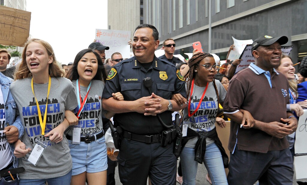 Houston Police Chief Art Acevedo, center, and Houston Mayor Sylvester Turner, far right, join demonstrators during a March for Our Lives protest for gun legislation and school safety Saturday, March 24, 2018, in Houston. Turner has told several thousand people demonstrating for stricter gun control that adults have a responsibility to stand up and protect all children. (AP Photo/David J. Phillip)