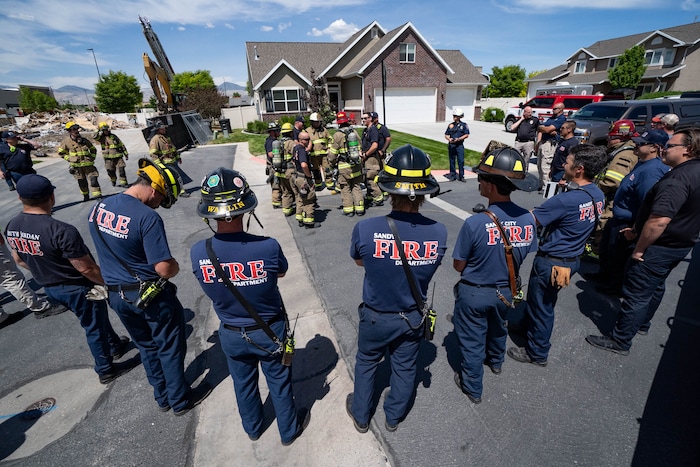 (Francisco Kjolseth | The Salt Lake Tribune) South Jordan tears down a house where an owner kept a stockpile of explosives, as firefighters huddle for a briefing before burning off residual explosives that remained in the basement of the home and could not be safely removed on Tuesday, June 1, 2021.