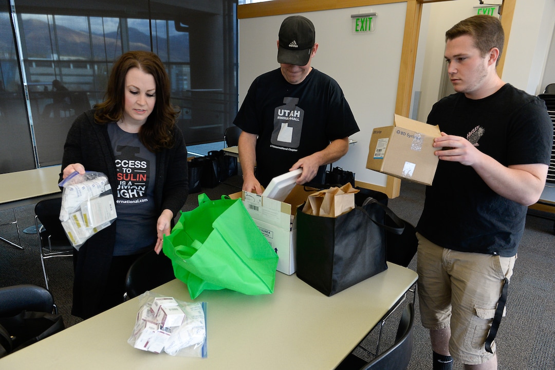 (Francisco Kjolseth | The Salt Lake Tribune)  Mindie Hooley is joined by her husband Jason and their son Dillon, 19, as they unpack insulin for donation to people with Type 1 diabetes,  before the start of a meeting of the support group T1 International in Salt Lake City, on Oct. 23, 2019. Dillion was  diagnosed with the disease in 2015 and at one time rationed his insulin because he was concerned with the financial burden it was causing the family.