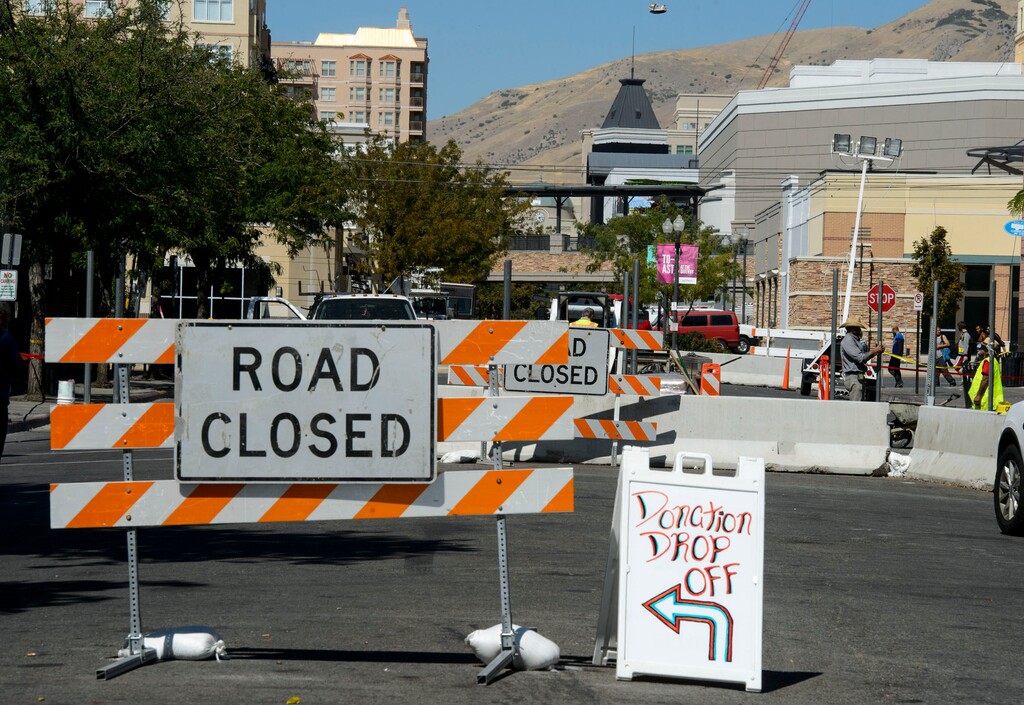(Steve Griffin | The Salt Lake Tribune) Workers cement fence posts into position on Rio Grande Street in Salt Lake City in September.