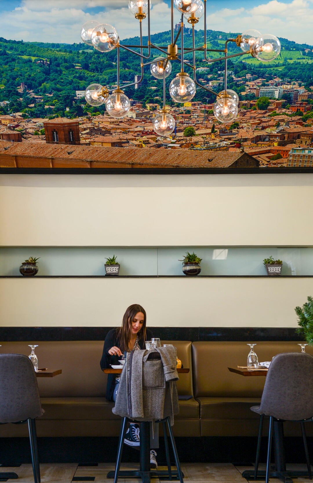(Leah Hogsten  |  The Salt Lake Tribune) Eloisa Grifo dines beneath a photograph of The Sanctuary of the Madonna of San Luca basilica church, Jan. 10, 2020, overlooking the town of Bologna, Italy, the beloved city of Osteria Amore owner Eduardo Daja, who took the picture.