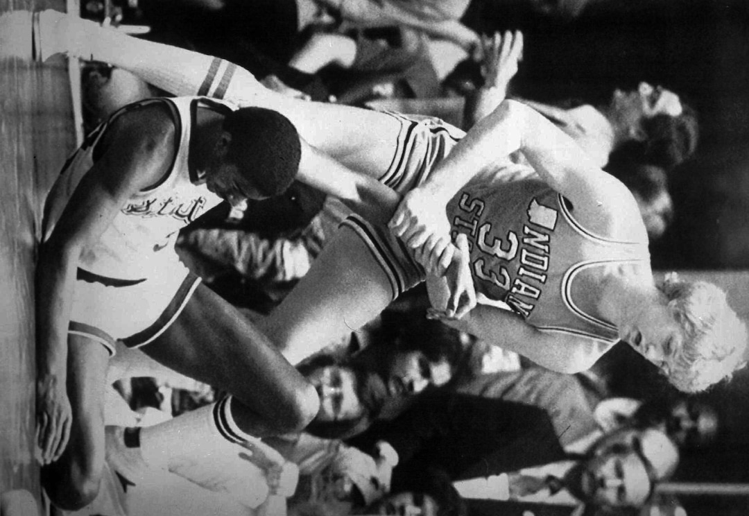 (AP Photo) Indiana State's Larry  Bird (33) gives a helping hand to a fallen Magic Johnson of Michigan State during the final game of the NCAA men's basketball championship in Salt Lake City in March 26, 1979. Because of the match-up of Bird vs. Magic, it became known as the game that changed college basketball.