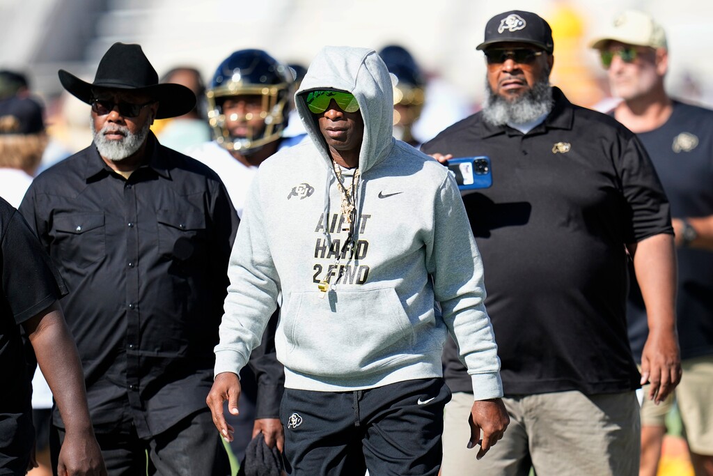 Colorado head coach Deion Sanders, center, walks on the field prior to an NCAA college football game against Arizona State, Saturday, Oct. 7, 2023, in Tempe, Ariz. (AP Photo/Ross D. Franklin)