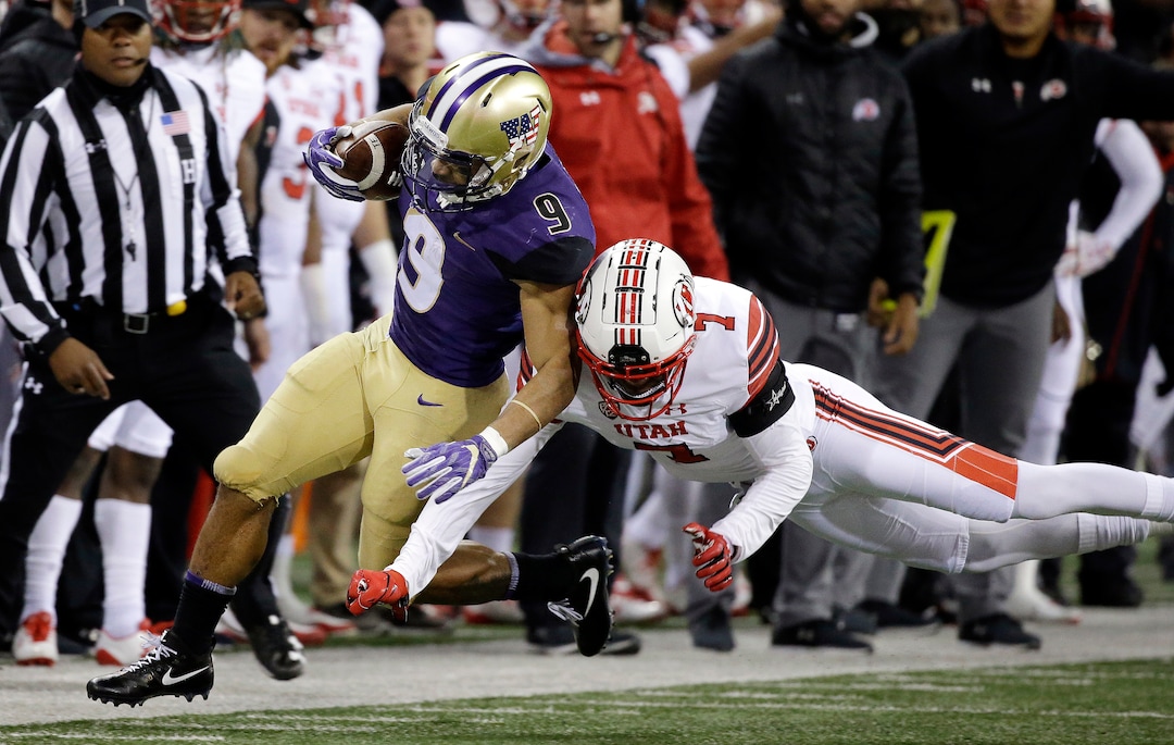 Washington's Myles Gaskin (9) is knocked out of bounds by Utah's Jaylon Johnson during the first half of an NCAA college football game Saturday, Nov. 18, 2017, in Seattle. (AP Photo/Elaine Thompson)