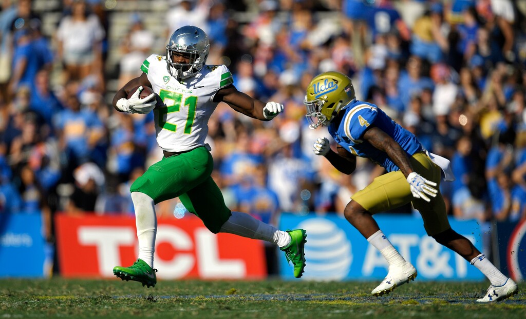 Oregon running back Royce Freeman, left, runs the ball as UCLA defensive back Jaleel Wadood defends during the second half of an NCAA college football game, Saturday, Oct. 21, 2017 in Pasadena, Calif. (AP Photo/Mark J. Terrill)