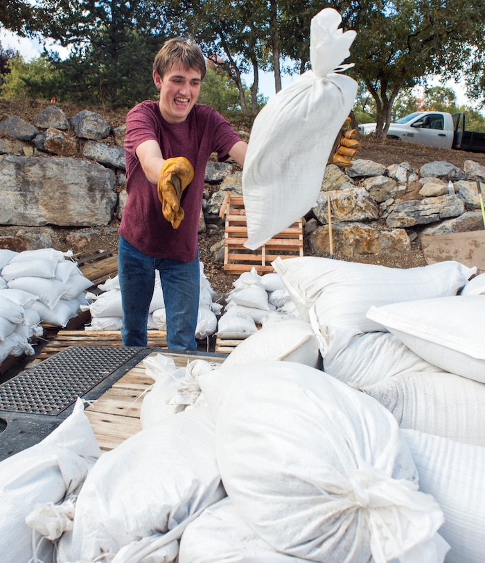 (Rick Egan  |  The Salt Lake Tribune)     Jacob Harding, 17, helps his neighbors from Woodland Hills stack sandbags at the Fire station, Monday, Oct. 1, 2018.


