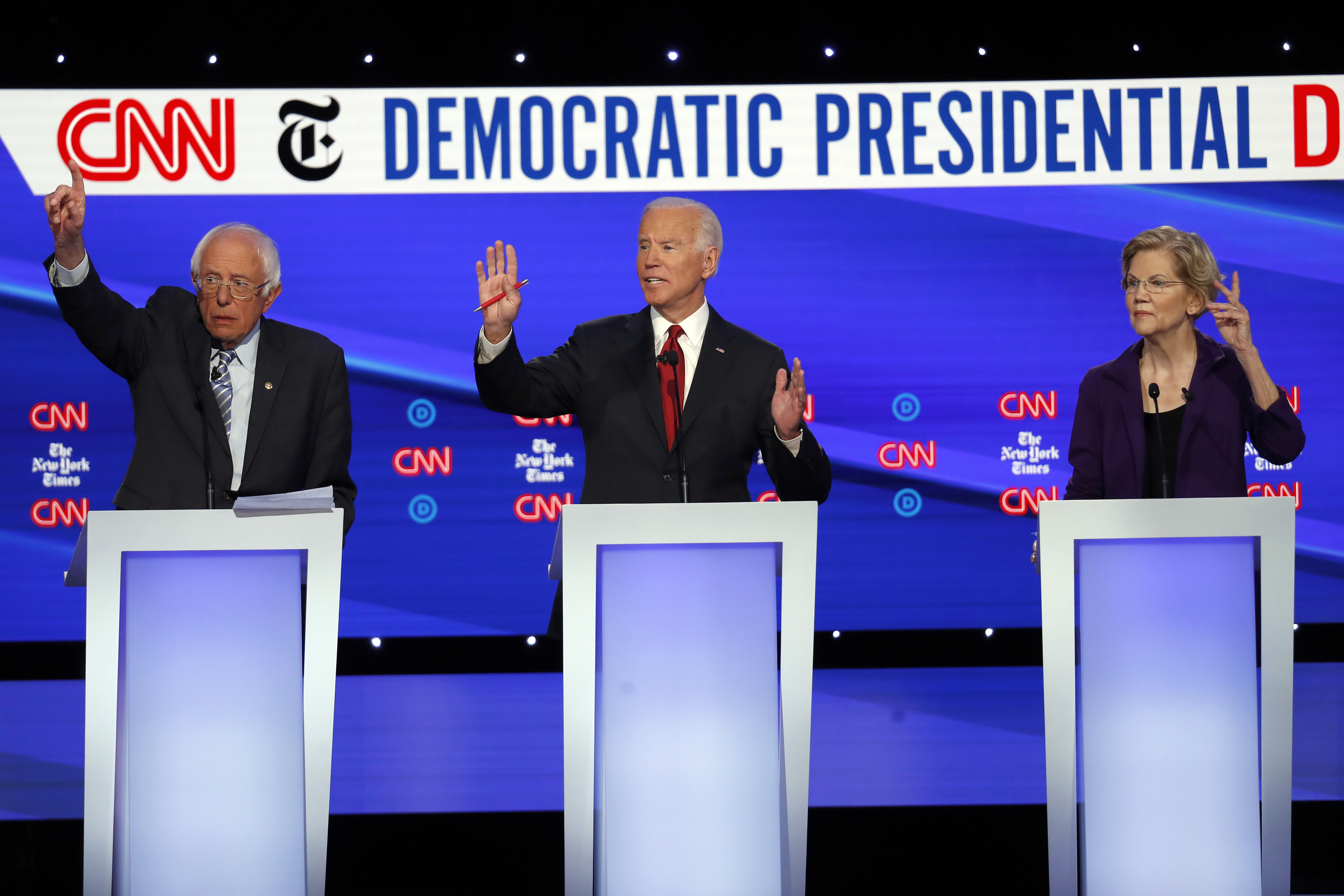 (John Minchillo | AP) Democratic presidential candidate Sen. Bernie Sanders, I-Vt., left, former Vice President Joe Biden, center, and Sen. Elizabeth Warren, D-Mass., raise their hands to speak during a Democratic presidential primary debate hosted by CNN/New York Times at Otterbein University, Tuesday, Oct. 15, 2019, in Westerville, Ohio.