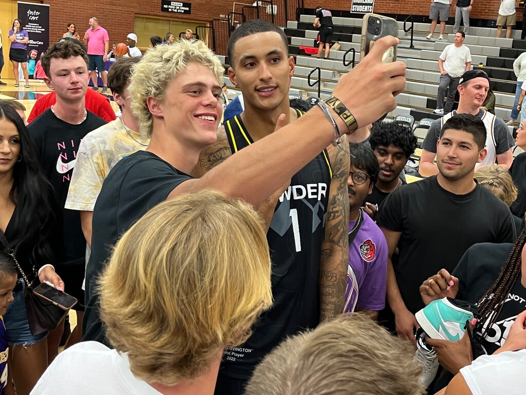 (Andy Larsen | The Salt Lake Tribune) Washington Wizards and former University of Utah forward Kyle Kuzma takes a photo with a fan at the pro-am Powder League's showcase game, Tuesday, Aug 9, 2022, in Salt Lake City.