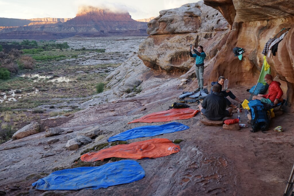 (Darius Nabors) Kayleen and Matt Castelli and Michael and Kathryn Heckendorn dry out their gear above the muddy Green River in Canyonlands National Park on Saturday, Aug. 20, 2022. Less than an hour earlier a flash flood ripped through the area. In Moab, the nearest city, the deluge caused what has been deemed a 100-year flood.