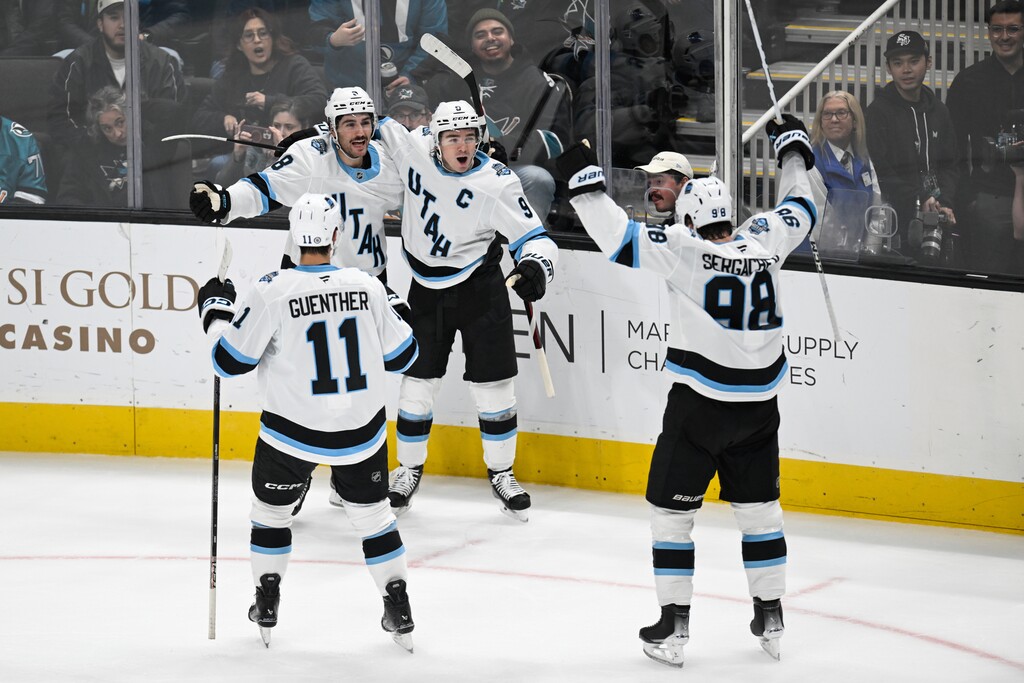 (Eakin Howard | AP) Utah Hockey Club center Clayton Keller (9) celebrates his goal with center Nick Schmaltz (8), right wing Dylan Guenther (11), and defenseman Mikhail Sergachev (98) against the San Jose Sharks during the third period of an NHL hockey game Saturday, Dec. 14, 2024, in San Jose, Calif. 