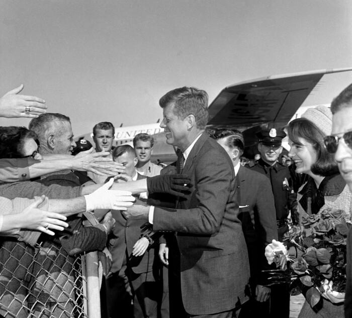 Hands reach out to greet President John F. Kennedy and first lady Jacqueline Kennedy upon their arrival at Dallas Love Field, Nov. 22, 1963. Later that day, the president was assassinated. (AP Photo)