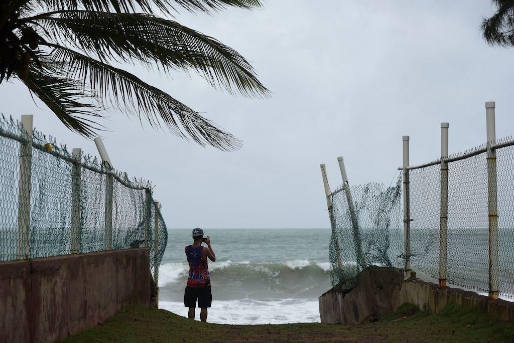 A man photographs the ocean before the arrival of Hurricane Irma, in luquillo, Puerto Rico, Wednesday, Sept. 6, 2017. Irma roared into the Caribbean with record force early Wednesday, its 185-mph winds shaking homes and flooding buildings on a chain of small islands along a path toward Puerto Rico, Cuba and Hispaniola and a possible direct hit on densely populated South Florida. (AP Photo/Carlos Giusti)