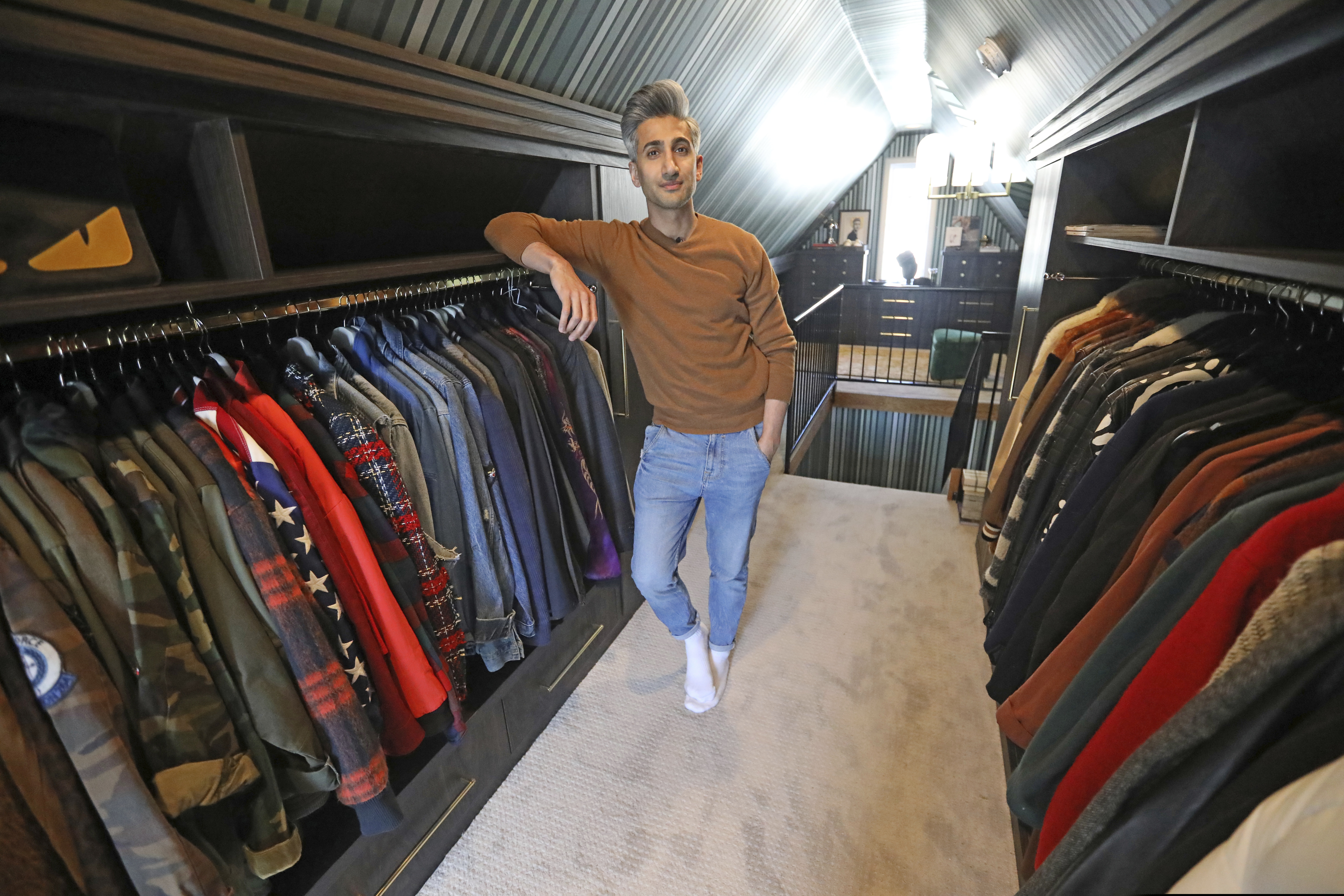 (AP Photo/Rick Bowmer) In this March 15, 2019, photo, Tan France, a cast member on the Netflix series "Queer Eye," poses among his clothes in the attic of his home in Salt Lake City. The series touches on some of the country's deepest divides with persistent optimism. The makeover program starring five gay men tackles the contrast between urban and rural, white and black, liberal and conservative.