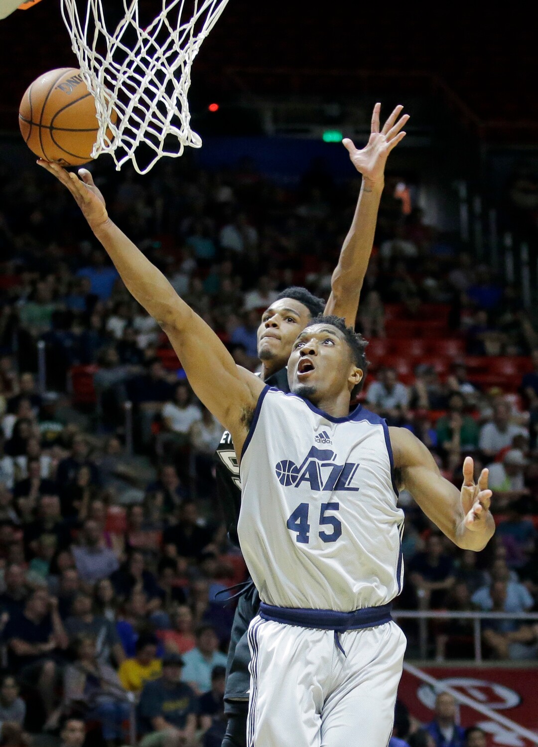 Utah Jazz guard Donovan Mitchell (45) lays the ball up as San Antonio Spurs guard Dejounte Murray, rear, defends during the first half of an NBA summer league basketball game Monday, July 3, 2017, in Salt Lake City. (AP Photo/Rick Bowmer)