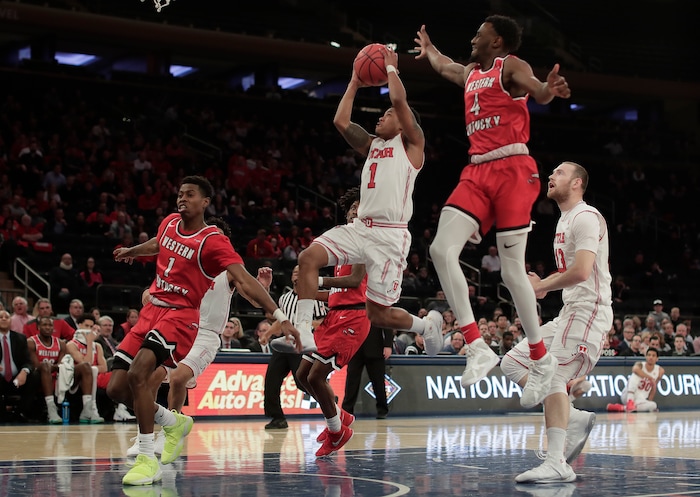 Utah guard Justin Bibbins (1) drives to the basket as Western Kentucky guards Lamonte Bearden (1) and Josh Anderson (4) defend during the first half of an NCAA college basketball game in the semifinals of the NIT, Tuesday, March 27, 2018, in New York. (AP Photo/Julie Jacobson)