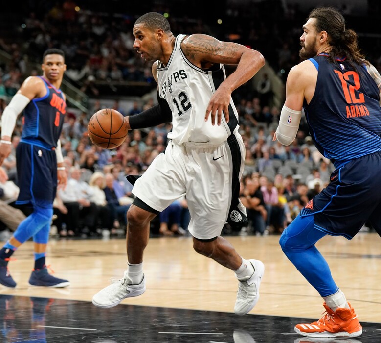 San Antonio Spurs' LaMarcus Aldridge, center, drives past Oklahoma City Thunder's Steven Adams, right, during the second half of an NBA basketball game Thursday, March 29, 2018, in San Antonio. San Antonio won 103-99. (AP Photo/Darren Abate)