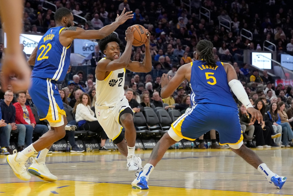 Utah Jazz guard Collin Sexton (2) drives to the basket against Golden State Warriors forward Andrew Wiggins (22) and forward Kevon Looney (5) during the second half of an NBA basketball game in San Francisco, Tuesday, Jan. 28, 2025. (AP Photo/Jeff Chiu)