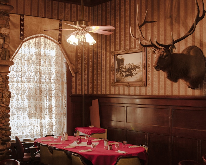 (Elliot Ross | The New York Times) The dining room of Buffalo Bill's Irma Hotel & Restaurant in Cody, Wyo., features photographs and taxidermy on Jan. 28, 2020. Last September, The Cody Enterprise reported that Kanye West bought a property called Monster Lake Ranch, about eight miles outside Cody.