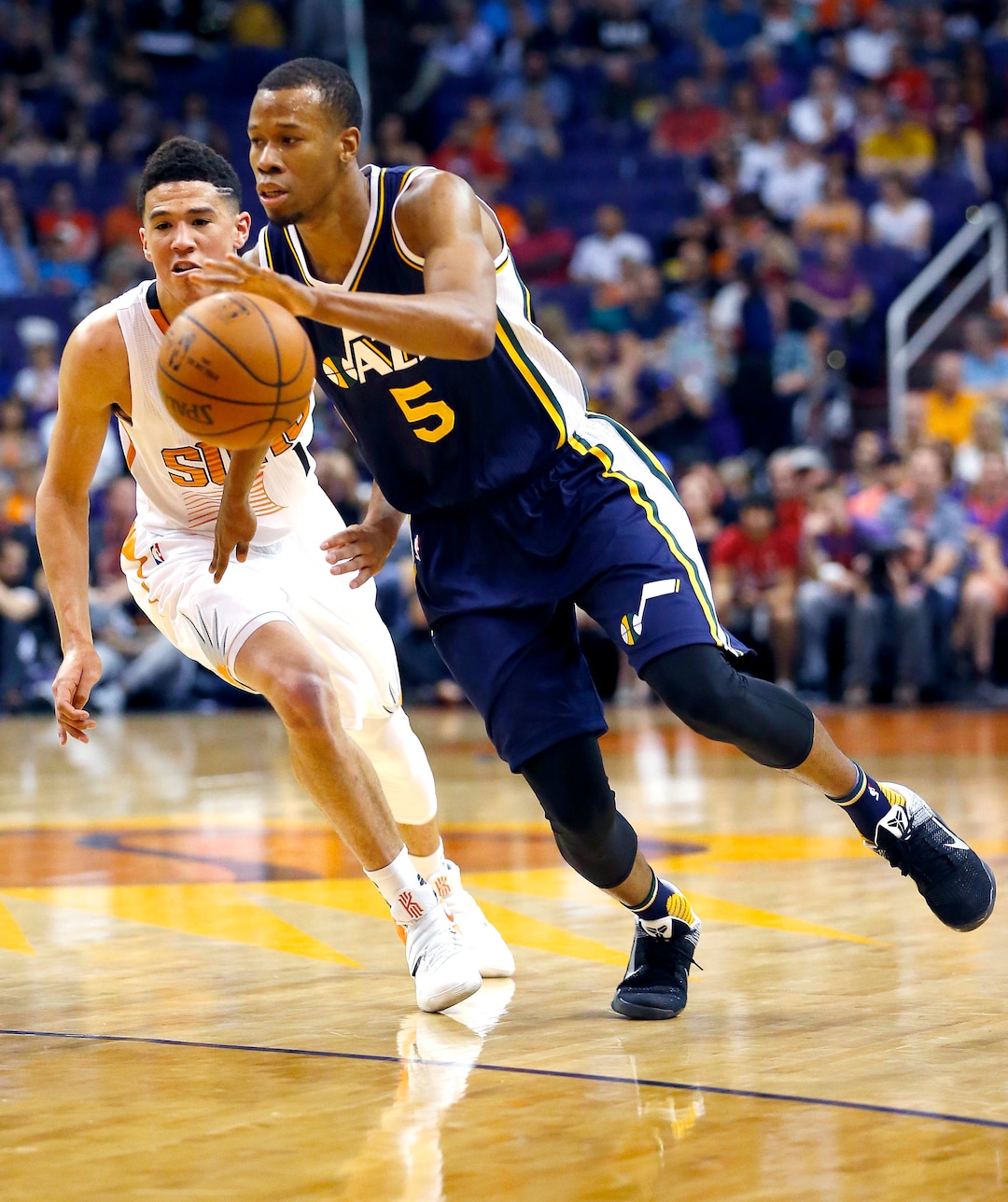 Utah Jazz guard Rodney Hood (5) drives past Phoenix Suns guard Devin Booker during the first half of an NBA basketball game, Sunday, April 3, 2016, in Phoenix. (AP Photo/Matt York)