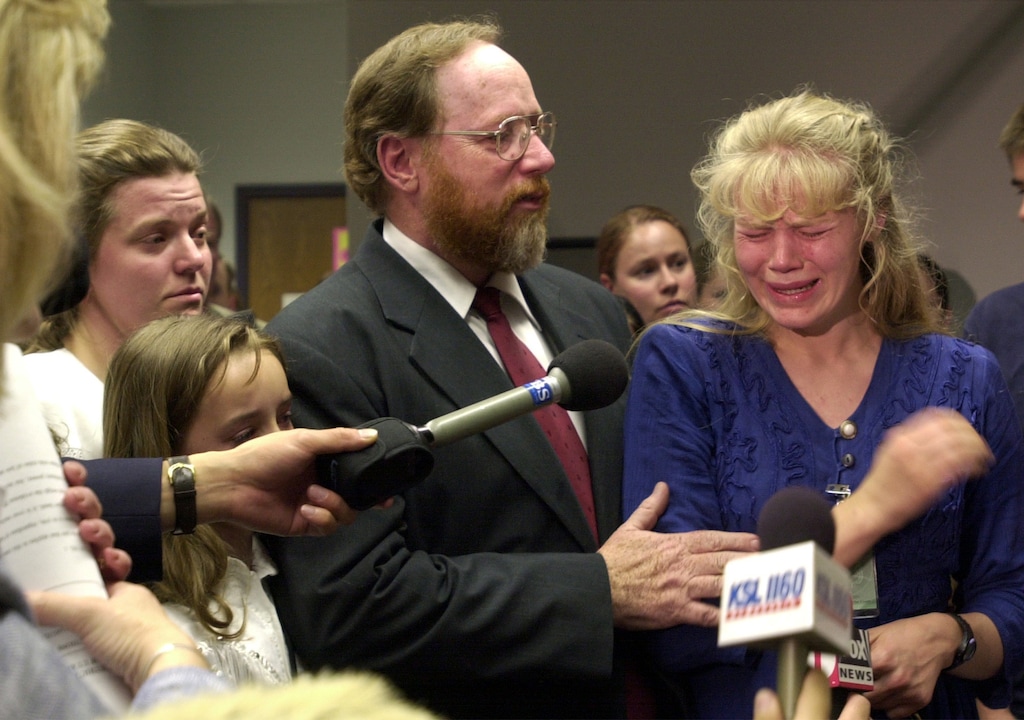 (Leah Hogsten | Tribune file photo)
After being found guilty on all counts of bigamy in 2001, Tom Green consoles his wife, Hannah Bjorkman, right, while giving a statement to the press.  Linda Kunz and Sierra Green are at left.