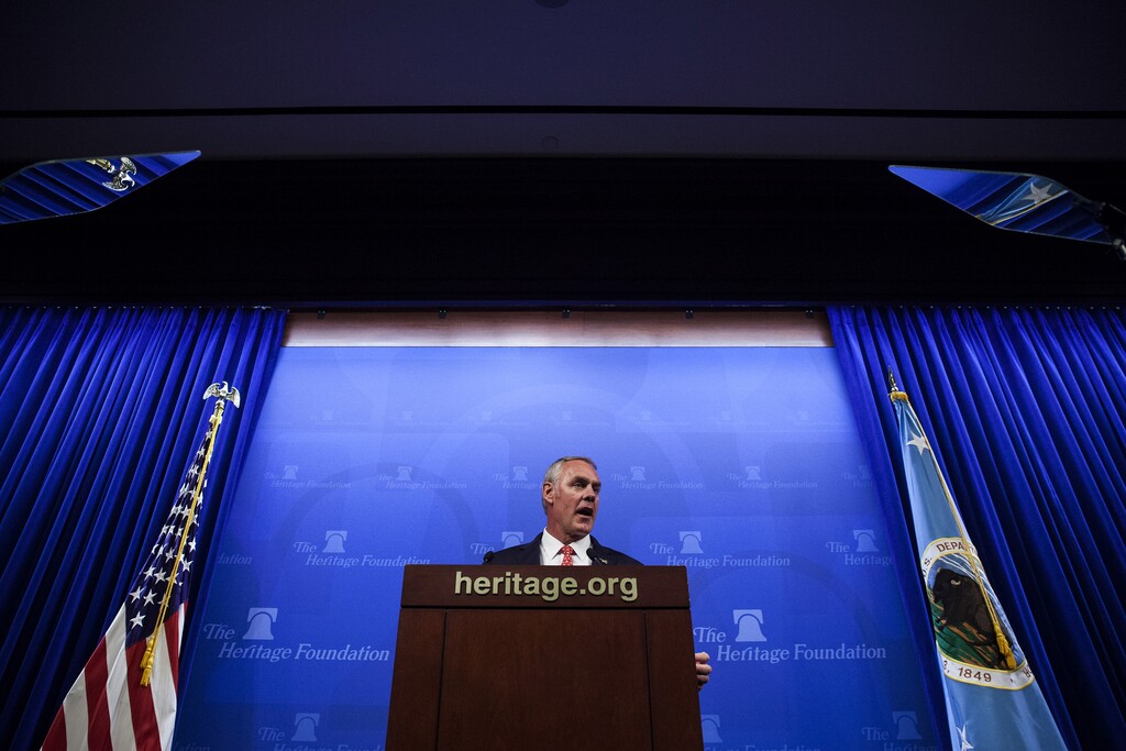 (Bloomberg photo by Zach Gibson) Interior Secretary Ryan Zinke speaks at the Heritage Foundation in Washington, D.C., in September. At right is his special secretarial flag.