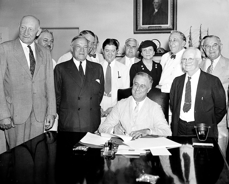 (The Associated Press) In this Aug. 14, 1935, file photo President Franklin Roosevelt signs the Social Security Bill in Washington.