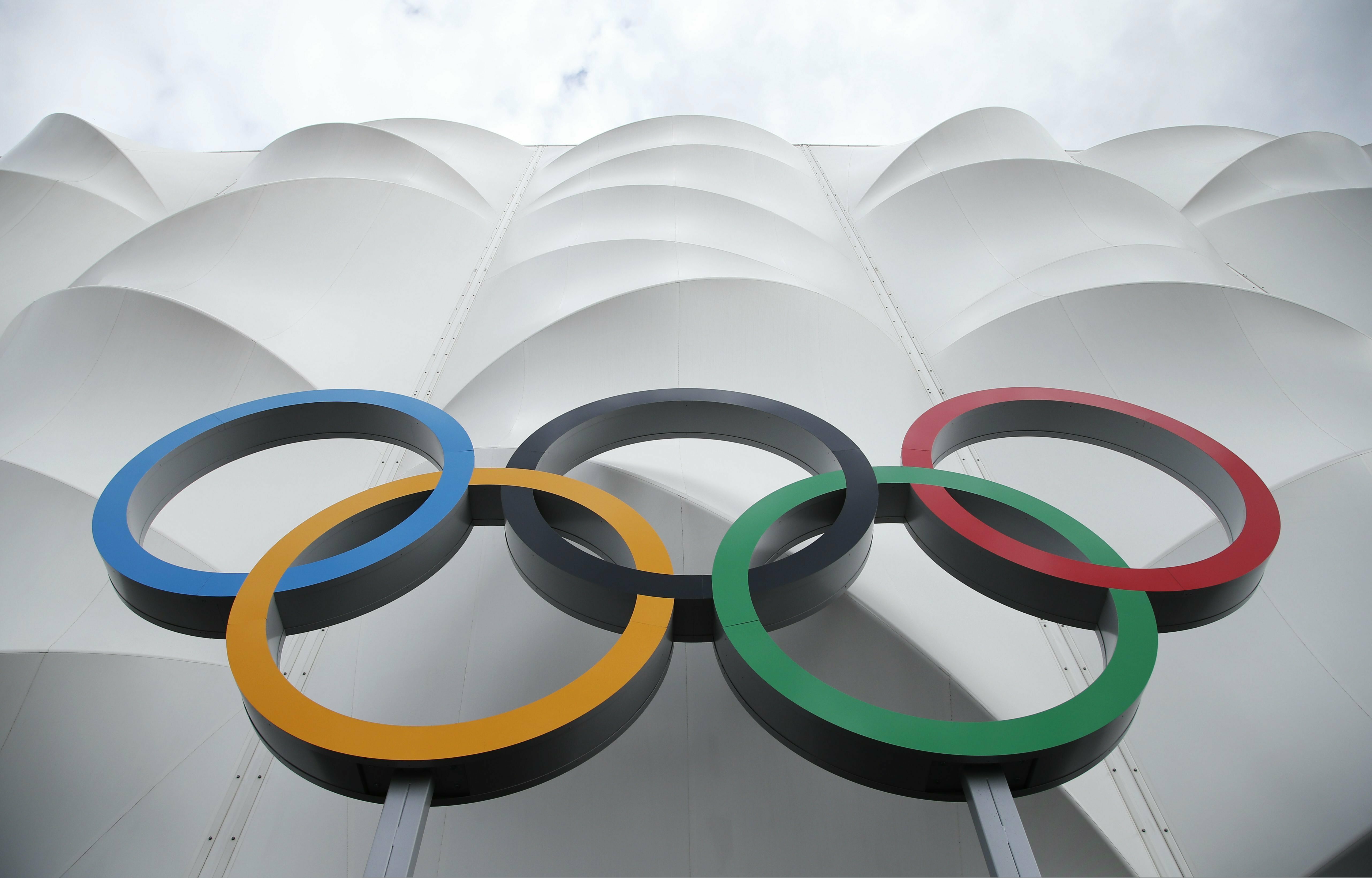 FILE - This July 15, 2012 file photo shows the Olympic rings displayed outside the basketball arena in the Olympic Park before the start of the 2012 Summer Olympics in London.  NBC Universal and the LA Olympics are going into business together, combining to package commercial time on all the network's platforms with opportunities to sponsor the American team through 2028. The deal is for contracts covering 2021 through 2028, the year the Summer Games return to the United States for the first time in 32 years. (AP Photo/Jae Hong, file)