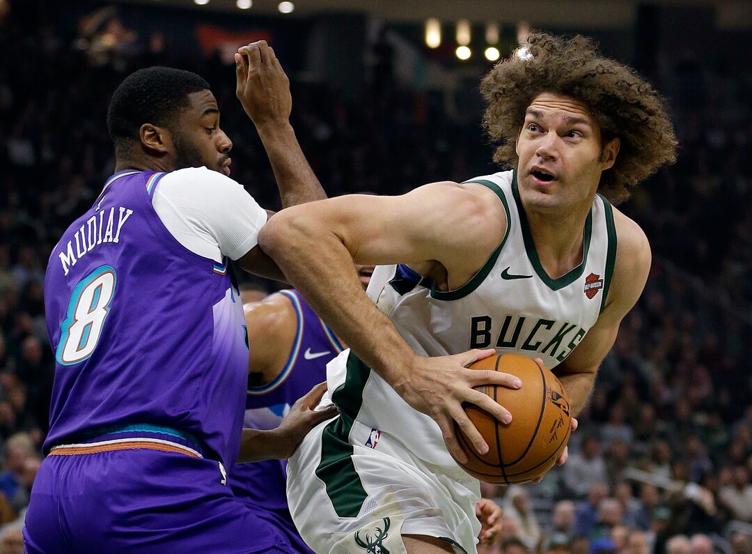 Milwaukee Bucks' Robin Lopez drives to the basket against Utah Jazz's Emmanuel Mudiay (8) during the first half of an NBA basketball game Monday, Nov. 25, 2019, in Milwaukee. (AP Photo/Aaron Gash)