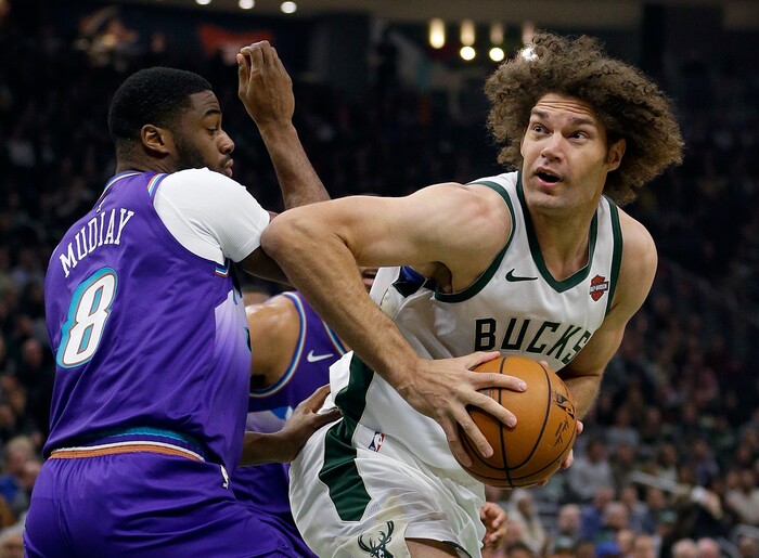 Milwaukee Bucks' Robin Lopez drives to the basket against Utah Jazz's Emmanuel Mudiay (8) during the first half of an NBA basketball game Monday, Nov. 25, 2019, in Milwaukee. (AP Photo/Aaron Gash)