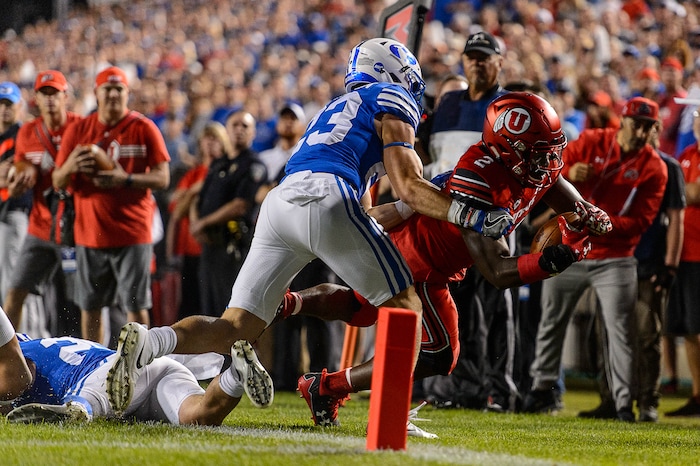 (Trent Nelson | The Salt Lake Tribune)  Utah Utes running back Zack Moss (2) is pushed out of bounds by Brigham Young Cougars defensive back Zayne Anderson (23) just short of the end zone as BYU hosts Utah, NCAA football in Provo, Saturday September 9, 2017.