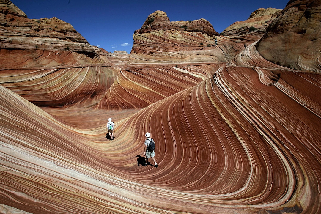 (Spencer Weiner  |  Los Angeles Times)  Hikers among the rock formations at "the Wave" in the Coyote Buttes area of the Paria Canyon-Vermillion Cliffs Wilderness on the Utah/Arizona border. Paria Canyon-Vermillion Cliffs Wilderness, Sept. 13, 2007. The Vermillion Cliffs Wilderness, near Page, Arizona is home to canyons and amazing rock formations. The area is so sensitive that the park service only allows a total of 20 people in the park per day. Permits are given through a lottery.