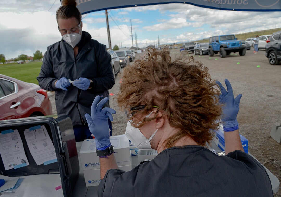 (Francisco Kjolseth  |  The Salt Lake Tribune) Registered nurse Jordan Eickbush, left, and lab tech Bryce Robinette perform COVID-19 antibody testing for people lined up at the Galena Hills Park in Draper on Wednesday, May 20, 2020.