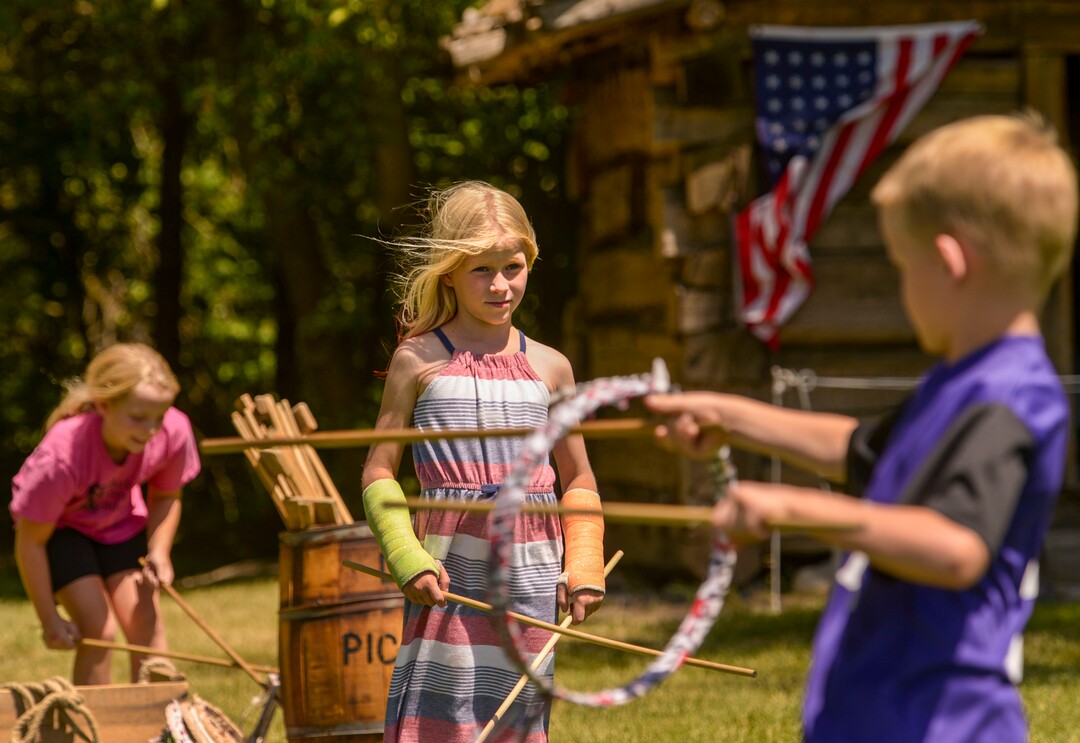 (Leah Hogsten  |  The Salt Lake Tribune) Kate Griffiths, 8, learns to play graces, a mid-1800s game with her brother Henry Griffiths, 5, during Pioneer Day festivities at the American West Heritage Center in Wellsville, July 24, 2020.
