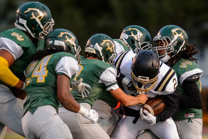 (Trent Nelson | The Salt Lake Tribune) Lone Peak's Brigham Trowbridge is stopped by a crowd of Kearns defenders as Kearns hosts Lone Peak, high school football, Thursday September 14, 2017.