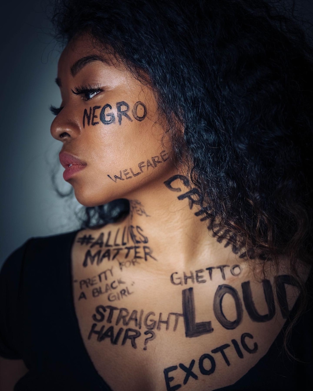 (Photo courtesy of Ana Brown Photo + Film) Up close photo of Stephanie Nguyen Lake covered with negative words associated with black women as she raises awareness for systemic inequality.