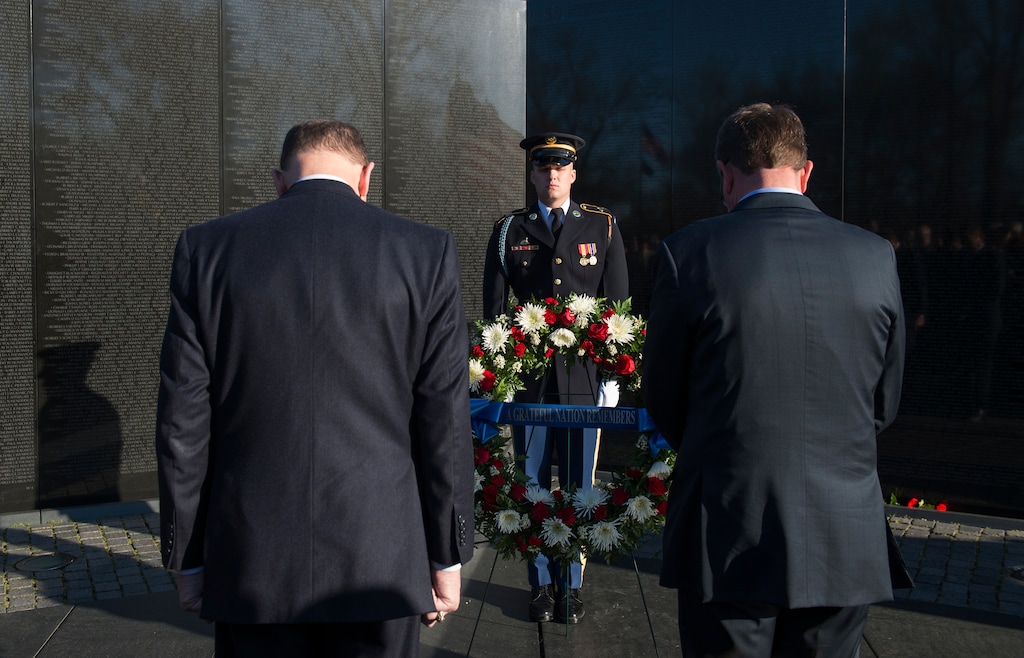 Defense Secretary Ash Carter, right and Veterans Affairs Secretary Robert McDonald, bow there heads in silence as they mark the 50th anniversary of the Vietnam War by laying a wreath at the Vietnam Memorial Wall in Washington, Tuesday, March 29, 2016. (AP Photo/Molly Riley)