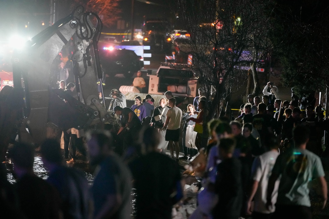 (Francisco Kjolseth | The Salt Lake Tribune) Sandbags are filled as numerous volunteers work to protect homes into the night along 1700 South in Salt Lake City from the rising flow of Emigration Creek through Wasatch Hollow Park on Wednesday, April 12, 2023. 