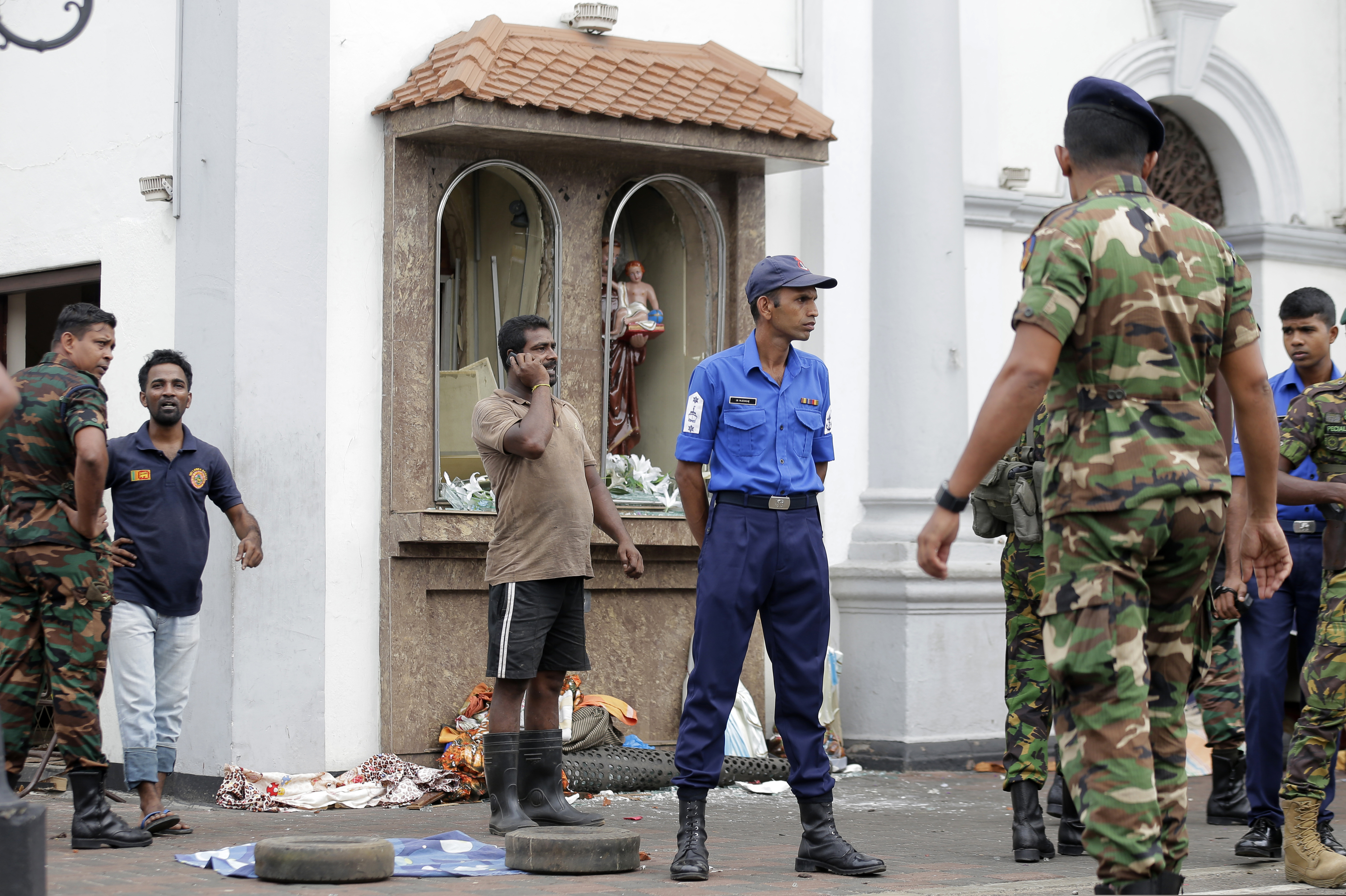 People gather outside St. Anthony's Shrine where a blast happened, in Colombo, Sri Lanka, Sunday, April 21, 2019. A Sri Lanka hospital spokesman says several blasts on Easter Sunday have killed dozens of people. (AP Photo/Eranga Jayawardena)