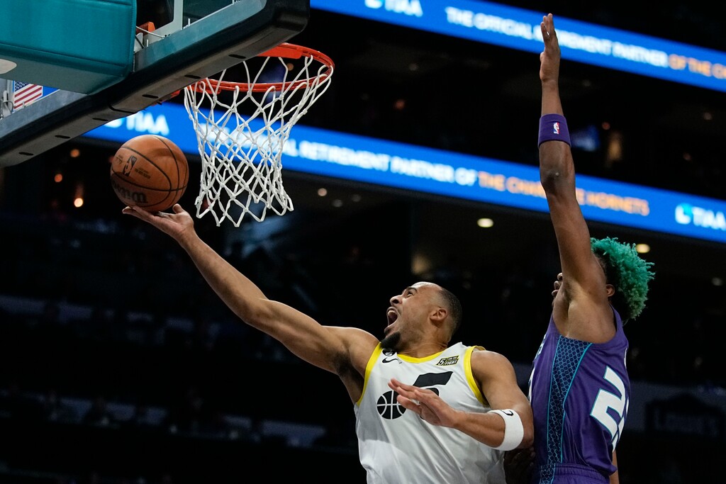 Utah Jazz guard Talen Horton-Tucker scores past Charlotte Hornets forward Kai Jones during the first half of an NBA basketball game on Saturday, March 11, 2023, in Charlotte, N.C. (AP Photo/Chris Carlson)