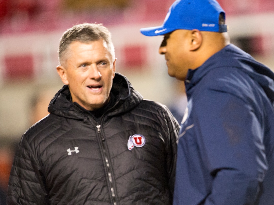 (Rick Egan  |  The Salt Lake Tribune)      Utah Utes head coach Kyle Whittingham visits with Brigham Young Cougars head coach Kalani Sitake, before football action between the Brigham Young Cougars and the Utah Utes, at Rice-Eccles Stadium, Saturday, November 24, 2018.