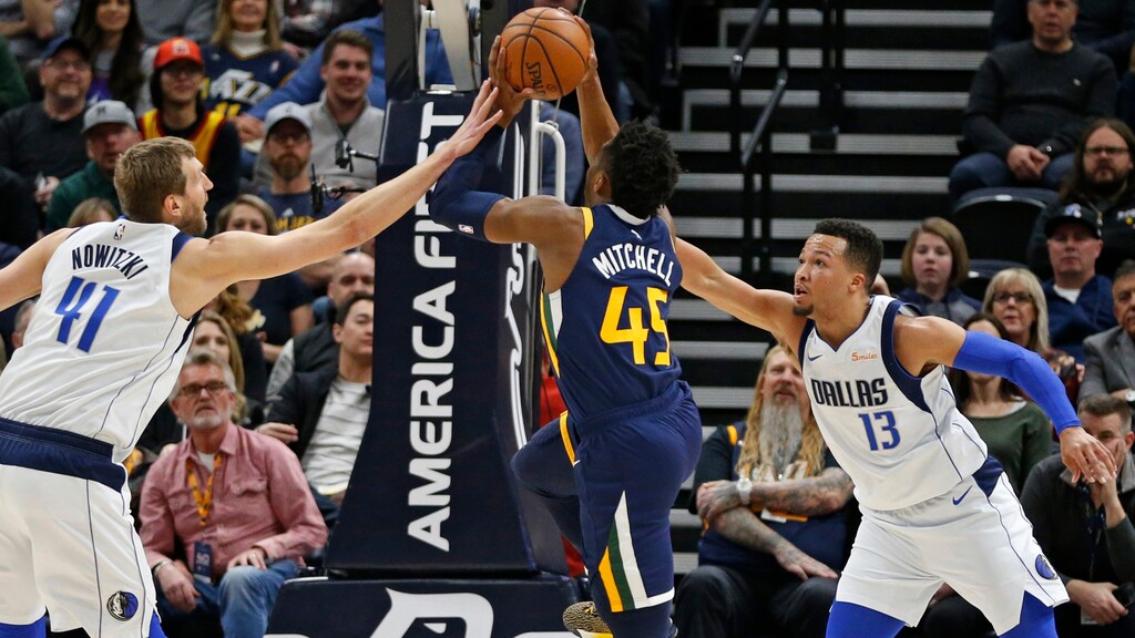 Utah Jazz guard Donovan Mitchell (45) goes to the basket as Dallas Mavericks' Dirk Nowitzki (41) and Jalen Brunson (13) defend during the first half of an NBA basketball game Saturday, Feb. 23, 2019, in Salt Lake City. (AP Photo/Rick Bowmer)