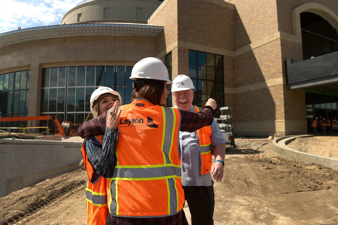 (Leah Hogsten  |  The Salt Lake Tribune)   Sandy City communications director Nicole Martin, (left) and Sandy City Mayor Tom Dolan laugh as Hale Centre Theatre vice president Sally Dietlein hug them on the theatre's construction site. The Mountain American Performing Arts Centre is the new 130,000 square feet home to new Hale Centre Theatre, August 8, 2017. 