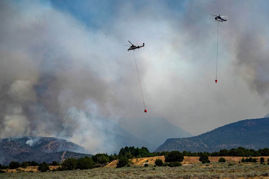 (Rick Egan | The Salt Lake Tribune) Helicopters work on the Widemouth 2 Fire near Fillmore on Aug. 3, 2026. Two firefighting pilots were killed in a helicopter crash.