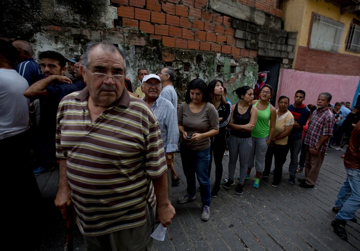 Voters wait in line to cast their ballots for regional elections outside a polling station in Caracas, Venezuela, Sunday, Oct. 15, 2017. Elections could tilt a majority of the states' 23 governorships back into opposition control for the first time in nearly two decades of socialist party rule, though the government says the newly elected governors will be subordinate to a pro-government assembly.(AP Photo/Fernando Llano)