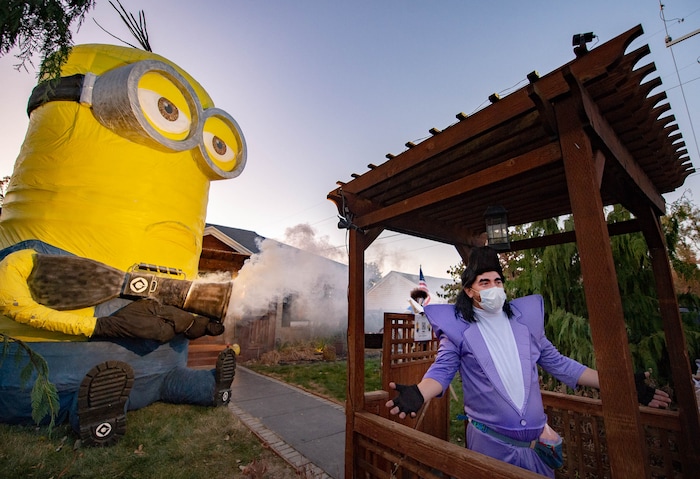 (Francisco Kjolseth  |  The Salt Lake Tribune) Ammon Smith dressed as the villain Balthazar Bratt from the movie Despicable Me goes big with his creation of a 25-foot Kevin, complete with fart gun in Sugar House on Saturday, Oct. 31, 2020, where he used a long tube to deliver candy for kids in an effort to stay safe during COVID-19 for this Halloween.