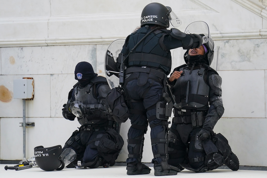 A police officer has eyes flushed with water after a confrontation with demonstrators, Wednesday, Jan. 6, 2021, at the Capitol in Washington. As Congress prepares to affirm President-elect Joe Biden's victory, thousands of people have gathered to show their support for President Donald Trump and his claims of election fraud.(AP Photo/John Minchillo)